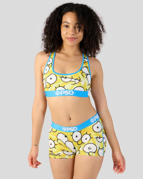 Yellow sports bra and shorts set featuring cartoon eyes pattern with blue PSD branding trim.