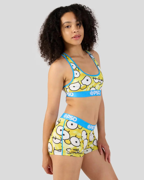 Women's sports bra and shorts set featuring yellow cartoon eyes pattern with blue waistband trim.