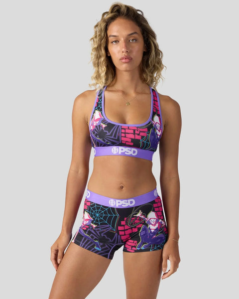 Woman wearing purple and pink Ghost-Spider sports bra and matching shorts with graphic comic-style print and PSD branding.