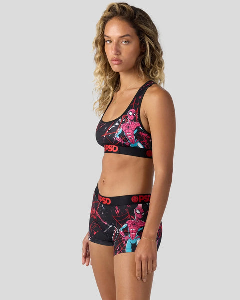 Woman wearing black sports bra and shorts with red Spider-Man character print and PSD branding.
