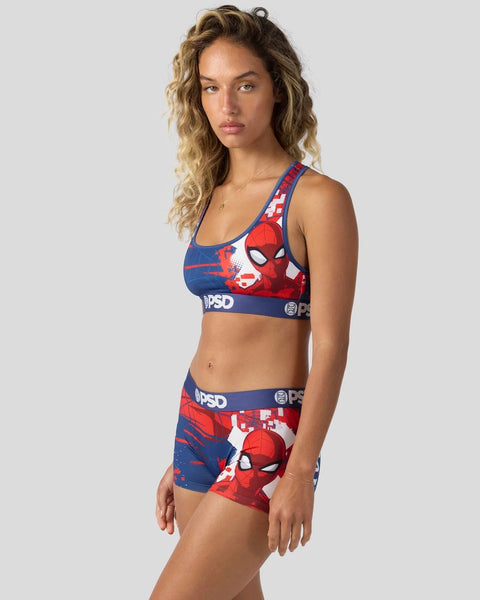 Woman wearing red and blue Spider-Man sports bra and matching shorts with character print and branded elastic waistband.