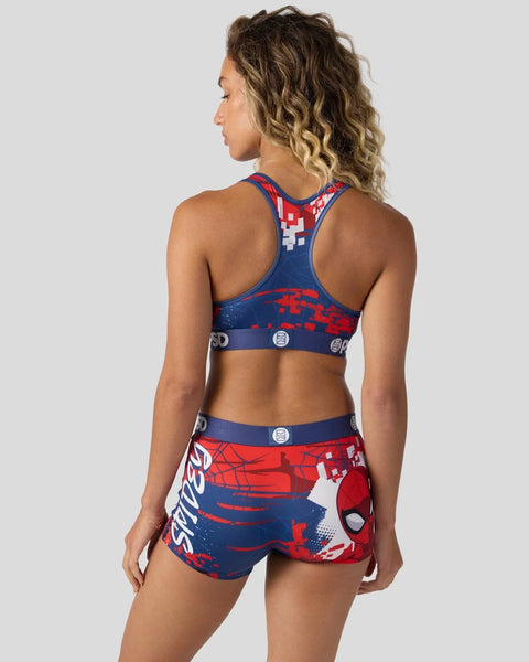 Woman wearing Spider-Man Senses sports bra and shorts set in red, blue, and white with web and character graphics.