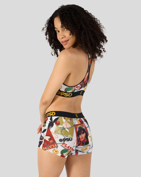 Woman wearing Playboy-branded sports bra and shorts with colorful holiday-themed print and black elastic waistband.