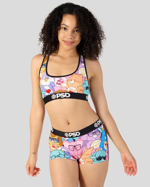 Woman wearing Care Bears-patterned sports bra and matching shorts with black PSD waistbands.