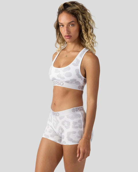 Woman wearing white camo sports bra and matching shorts with branded waistband.