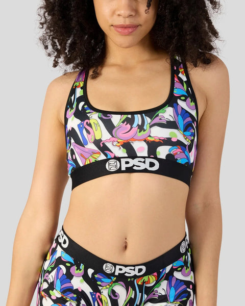 Woman wearing PSD sports bra with black waistband and colorful mushroom print on white and black background.