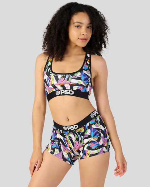 Woman wearing PSD Mushrooms sports bra and shorts set with colorful mushroom print on black background.