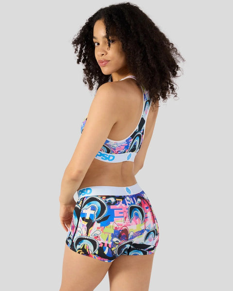 Woman wearing colorful shark-patterned sports bra and shorts set with blue and white trim.