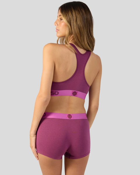 Magenta purple racerback sports bra and matching shorts with contrast waistband and button details.