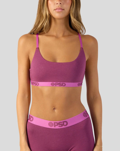 Woman wearing magenta modal sports bra with matching waistband and pink straps.