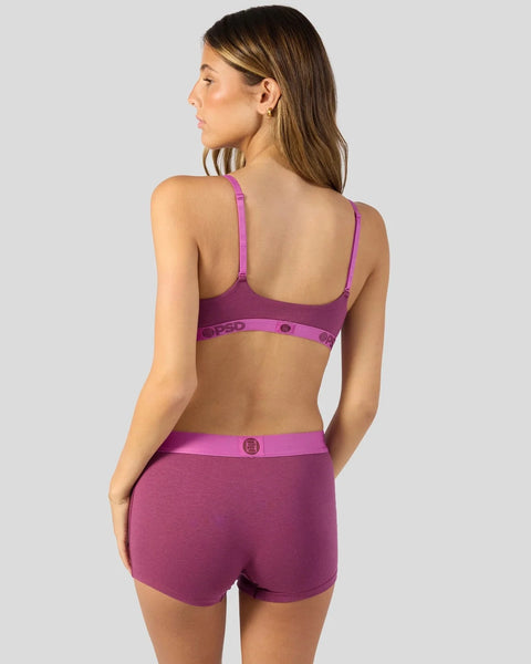 Woman wearing magenta purple bra and matching shorts set with adjustable straps and branded waistband detail.