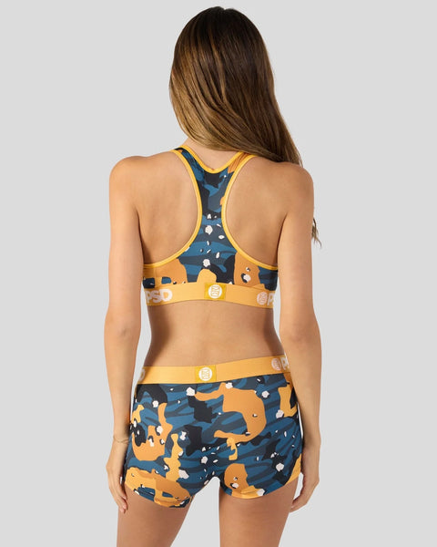 Three-piece athletic set with navy and gold patterned sports bra, matching shorts, and gold waistband with circular buckle de