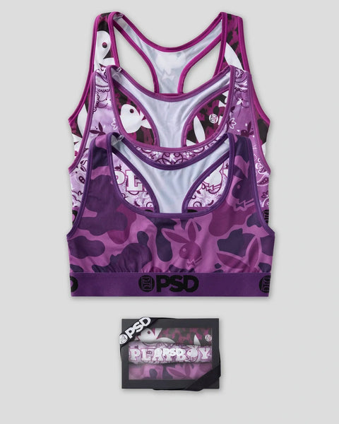 Three purple sports bras with varying patterns displayed with packaging box featuring Playboy and PSD branding.