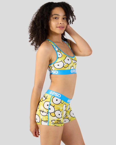Woman wearing yellow and blue Simpsons-themed sports bra and shorts with large eye graphics and blue waistbands.