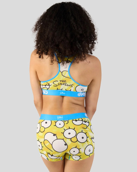 Simpsons-themed sports bra and shorts set with yellow background featuring large cartoon eyes and blue trim bands.