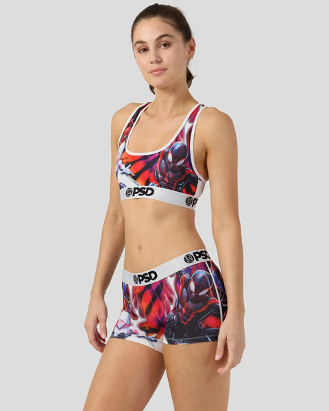 Woman wearing Spider-Man Triad sports bra and boy shorts with red and black character graphics and white PSD branding.