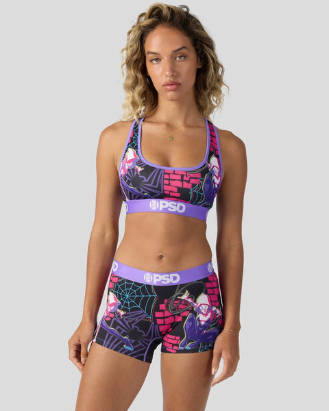 Woman wearing purple and pink Ghost-Spider sports bra and shorts set with web and brick pattern design.