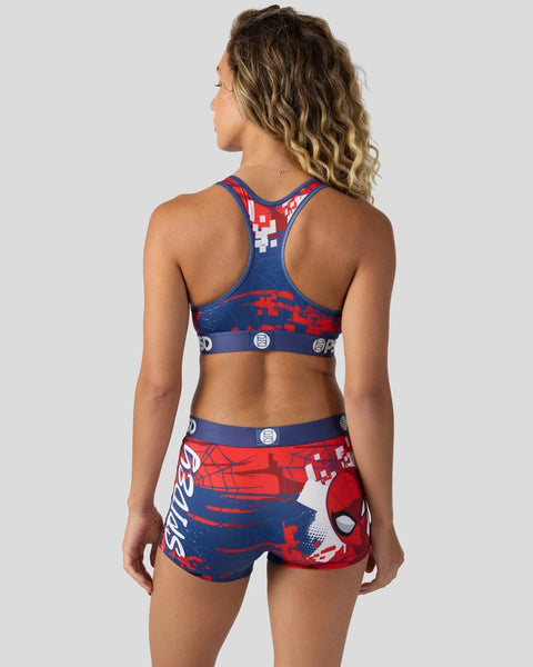 Woman wearing Spider-Man sports bra and shorts set in red, blue, and white with web and character graphics.