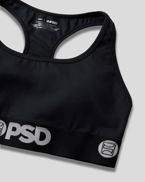 Black racerback sports bra with PSD branding and care label visible on interior.