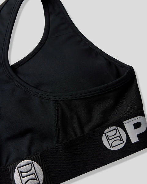 Black sports bra with wide straps, round neckline, and circular logo patches on the lower sides.
