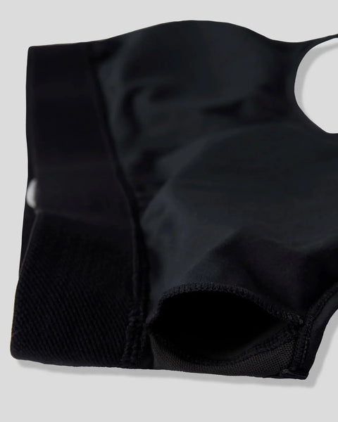Black fabric with textured mesh paneling and curved waistband detail.