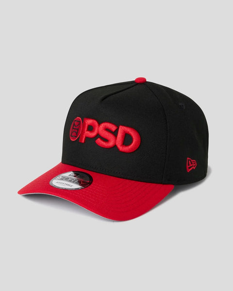 Black and red baseball cap with red "PSD" embroidered logo on front and New Era brand flag on side.