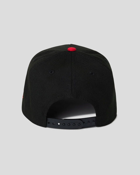 Black baseball cap with red logo patch on crown and black snapback closure.