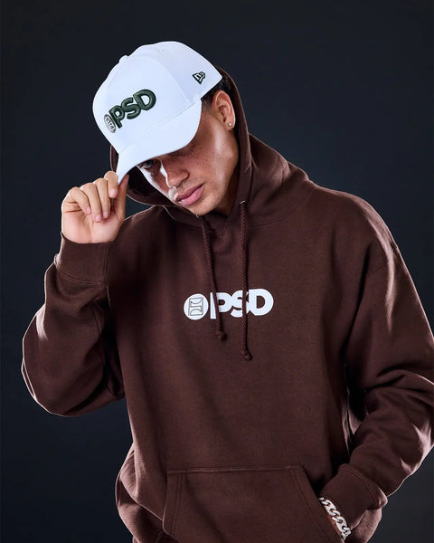 White baseball cap with green PSD logo on front and New Era branding on side panel.
