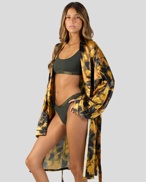Woman wearing olive sports bra and briefs with gold and black leopard print silk robe.