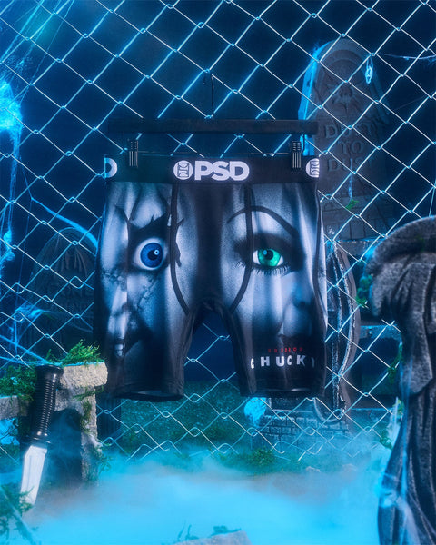 Black PSD shorts with Chucky's Bride graphic featuring doll faces with contrasting blue and green eyes.