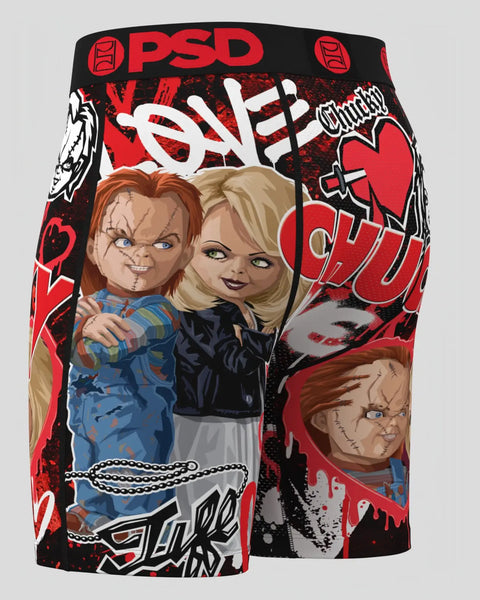 PSD Chucky shorts featuring Chucky doll in blue overalls and Tiff in black jacket with red and black graphic print.