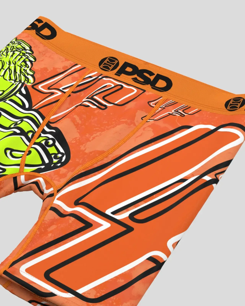 Orange PSD briefs with black and white geometric striping and neon yellow alien graphic detail on waistband.