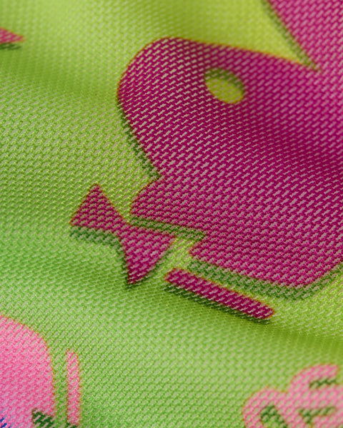 Neon green mesh fabric with hot pink Playboy bunny logo and geometric pattern detail.