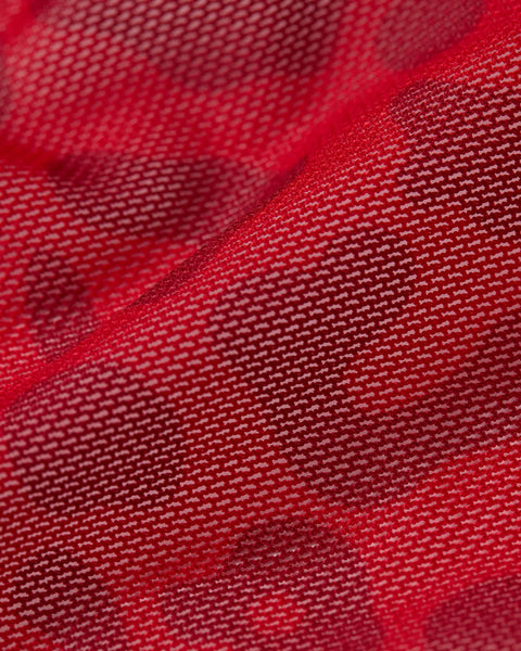 Red mesh fabric with woven texture and soft folds.