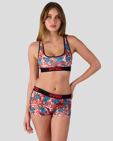 Woman wearing red, blue, and white patterned sports bra and matching shorts with black elastic waistbands.