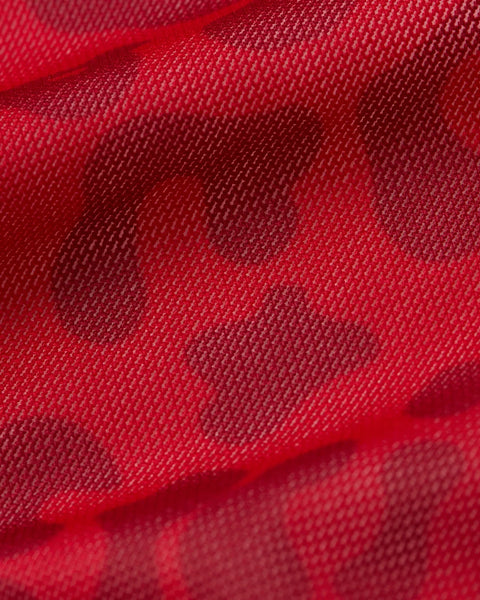 Red mesh fabric with woven texture and soft folds.