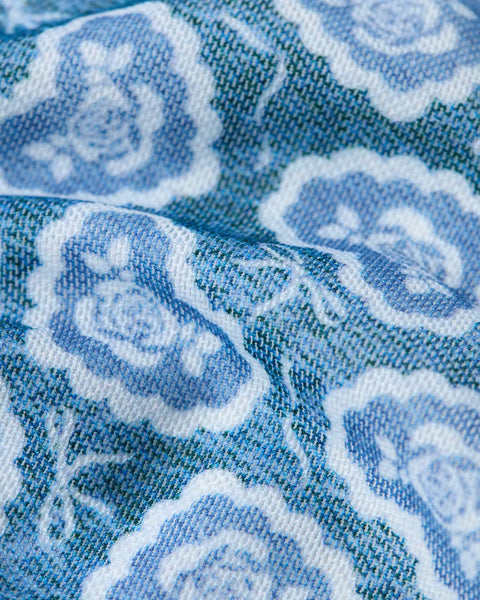 Blue and white mesh fabric with ornamental damask pattern, close-up of woven texture.