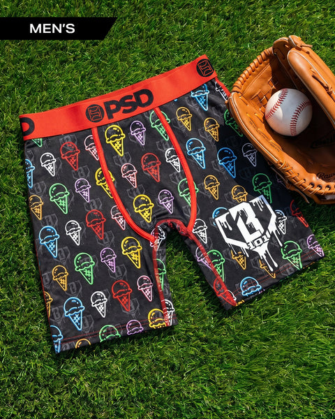 Men's black boxer briefs with colorful ice cream cone pattern, red waistband, displayed on grass with baseball glove and ball
