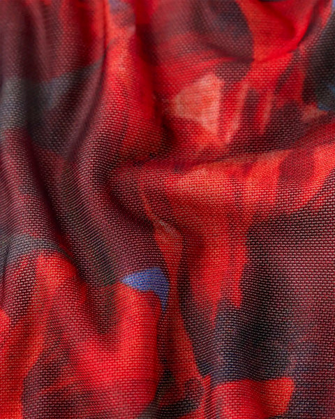 Red and charcoal knit fabric with poppy flower pattern and textured weave.
