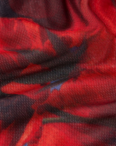 Red and black plaid woven fabric with blue accents, showing textured weave detail.