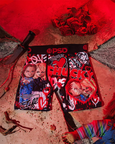 PSD brand underwear with Chucky and Tiffany character graphics displayed flat on red background with knife and roses.