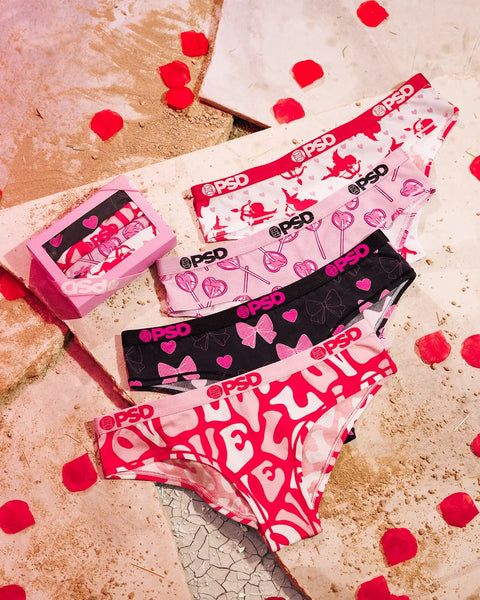 Four modal briefs with varying prints in pink, black, and red displayed on textured surface with scattered red petals.